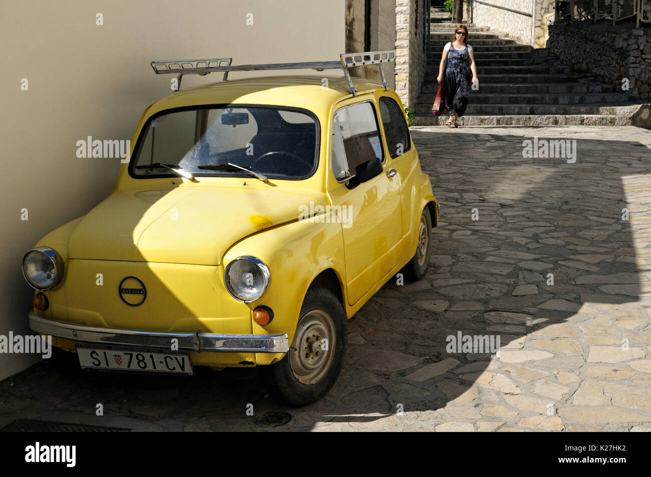 Old Zastava yellow car parked in a street of Primosten, Croatia Stock Photo