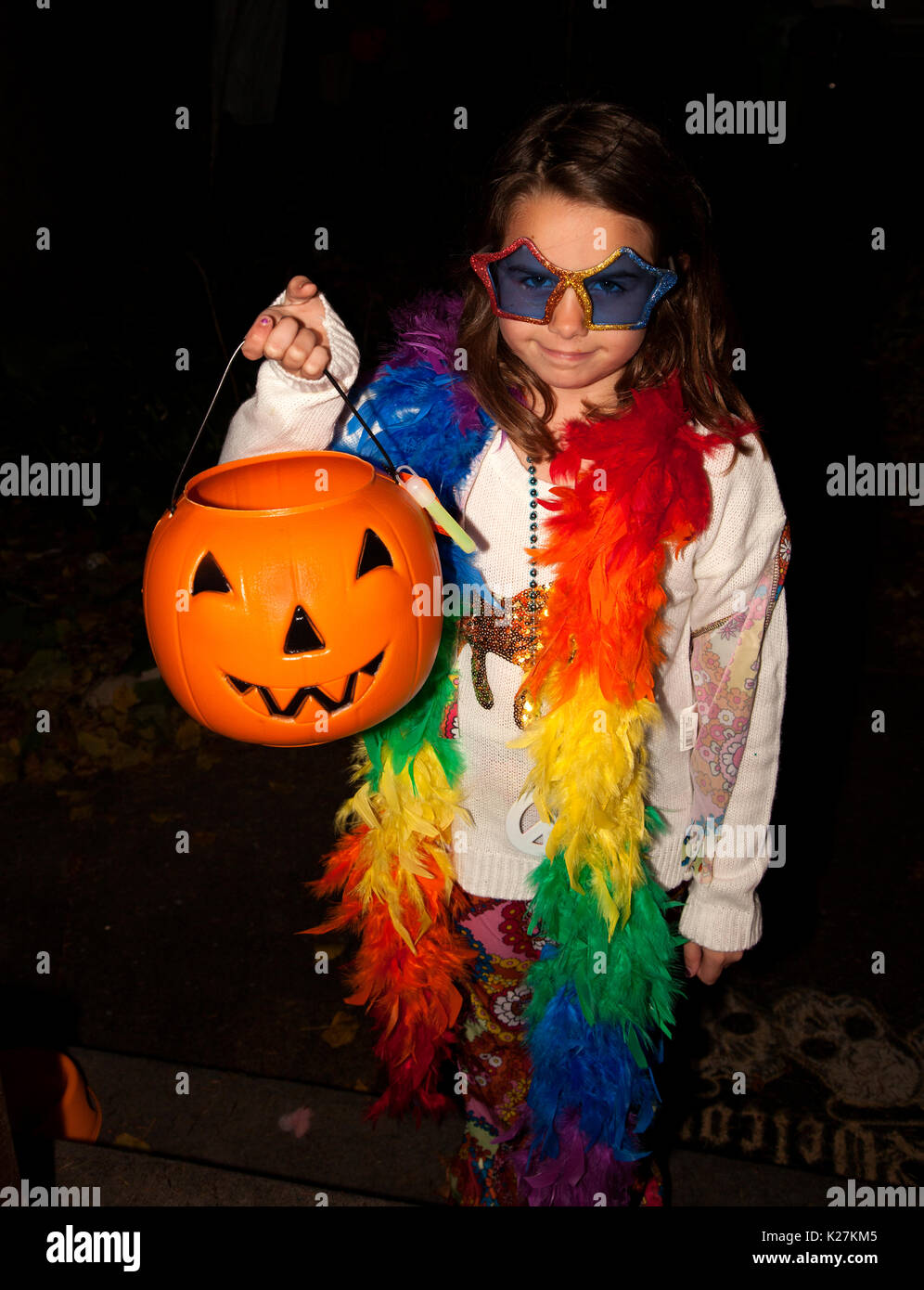 Halloween trick and treater holding a jacko'lantern pumpkin with a