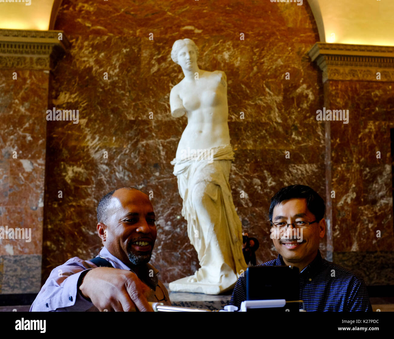 People pose and take selfies with Venus De Milo at the Louvre museum in Paris, France on September 17, 2016. Stock Photo