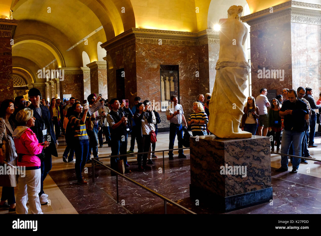 People pose and take selfies with Venus De Milo at the Louvre museum in Paris, France on September 17, 2016. Stock Photo
