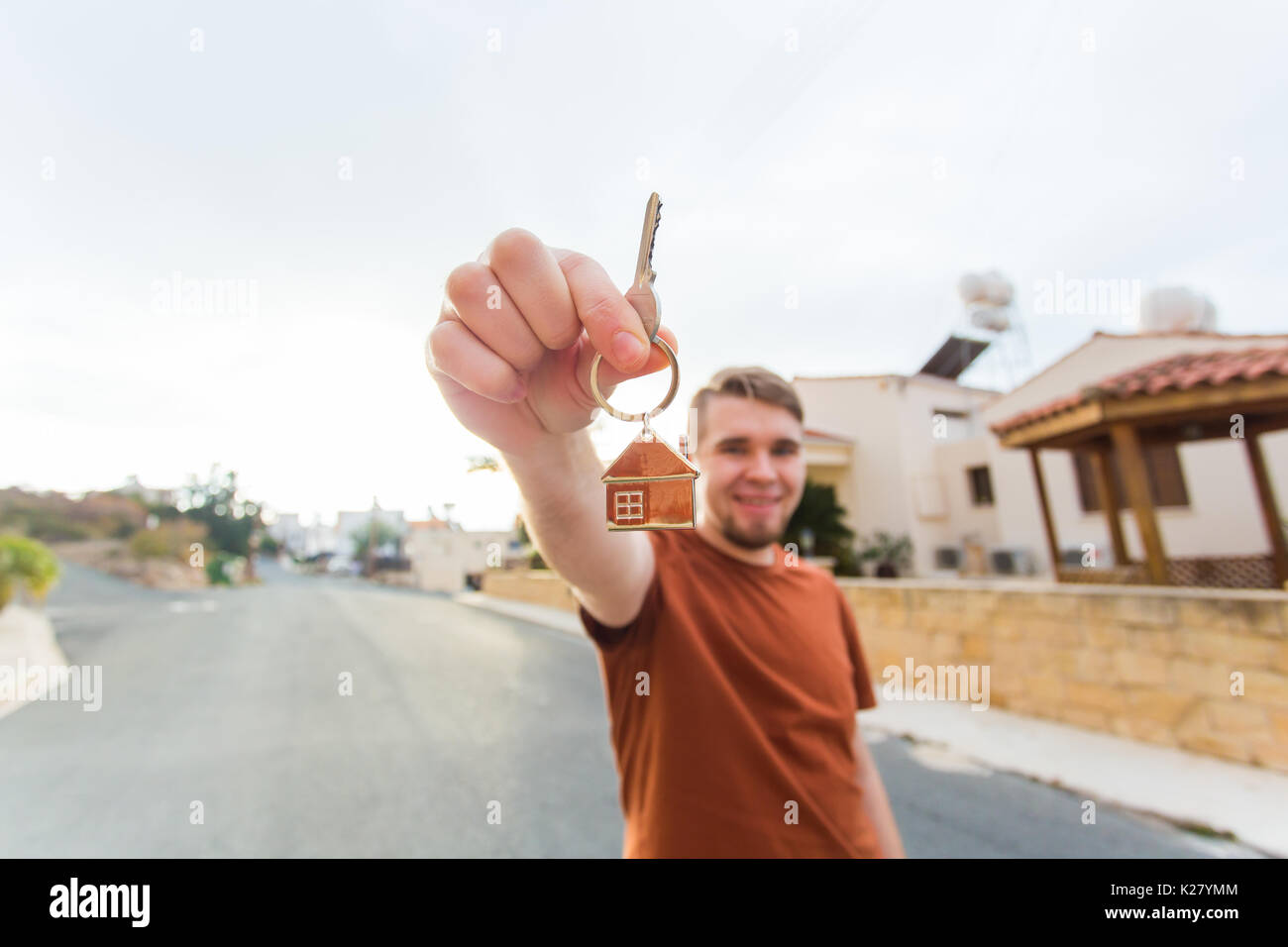 Young smiling man showing keys to new home. Real estate, apartment and ...