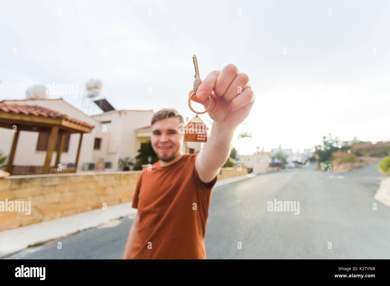 Happy young man showing off the key to his new home. Owner, real estate ...