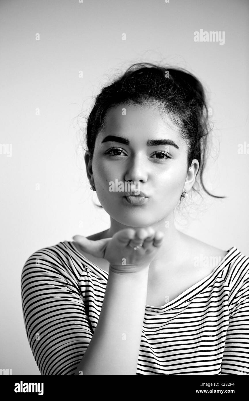 Cute lovely young woman standing and sending kiss over white background.Flying Kiss,Woman in Love ., black and white Stock Photo