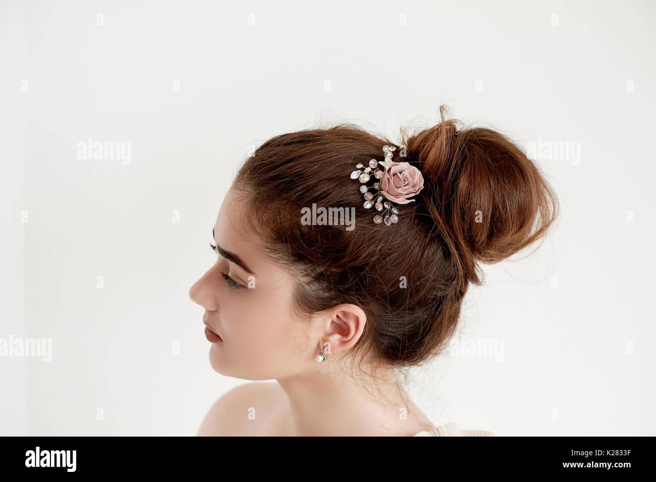 Portrait of beautiful girl with dark hair and light porcelain skin. Hair in a bun.Hair accessory handmade Stock Photo