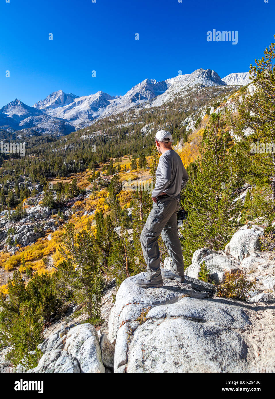 Hiker at overlook by the Mono Pass Trail at Little Lakes Valley in Rock Creek Canyon in autumn Stock Photo