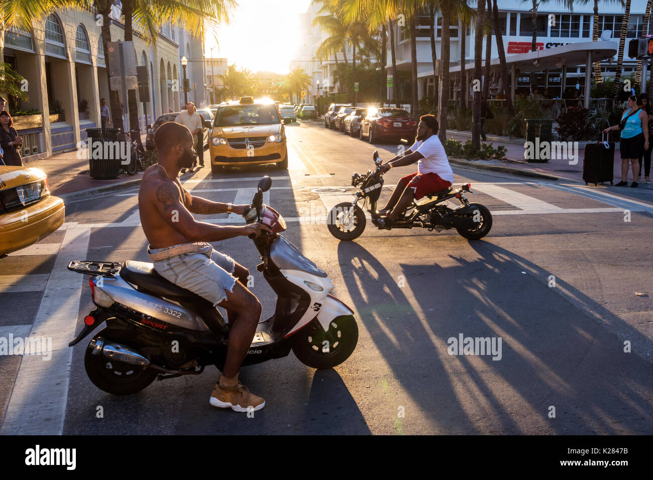 Miami Beach Florida,Ocean Drive,street,back lit,motor scooter scooters