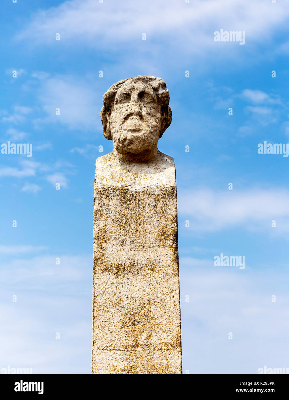 Weathered marble column with a head at the top amid the archaeological ruins, Delos, Greece Stock Photo