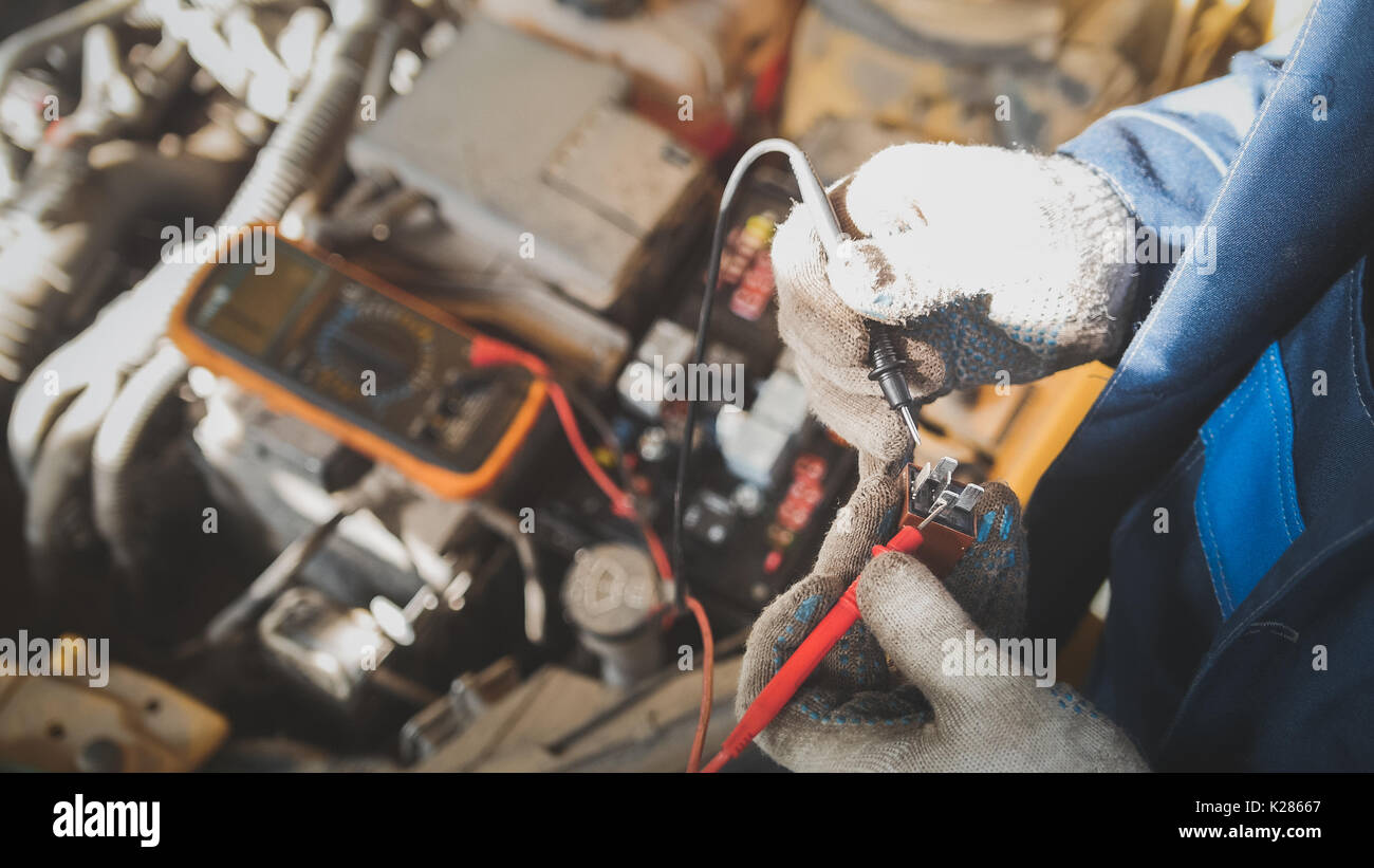 Mechanic in auto works with car electrics electrical wiring