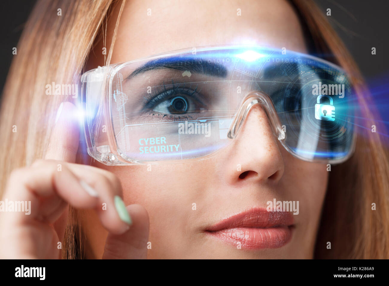 Business, Technology, Internet and network concept. Technology future. Young businesswoman working in virtual glasses, select the icon Cyber security  Stock Photo