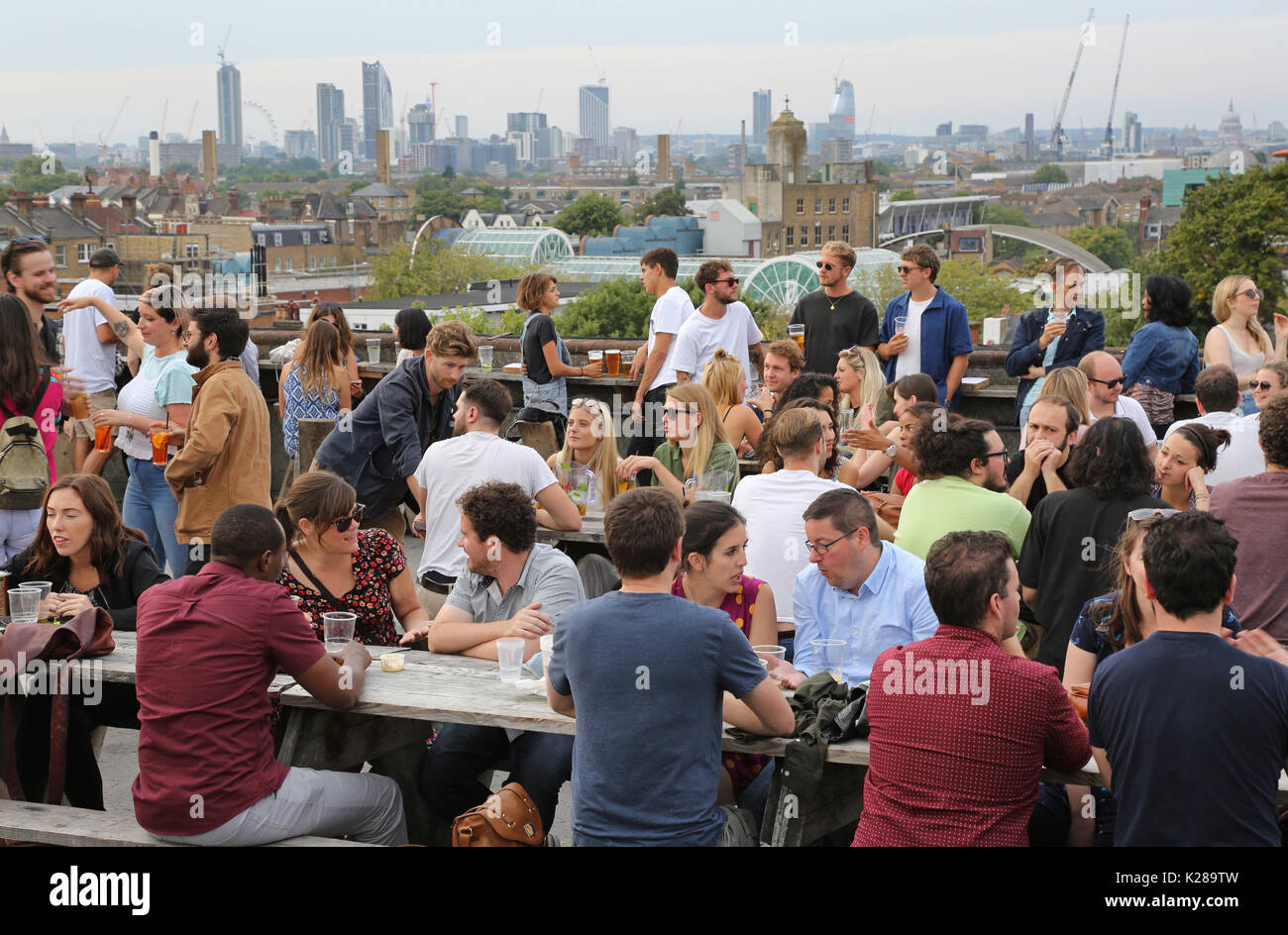 Customers at Frank's Café, the famous roof-top bar and restaurant on the multi-storey car park in Peckham, UK, overlooking the London skyline. Stock Photo