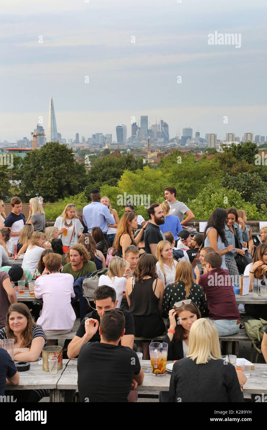 Customers at Frank's Café, the famous roof-top bar and restaurant on the multi-storey car park in Peckham, UK, overlooking the London skyline. Stock Photo
