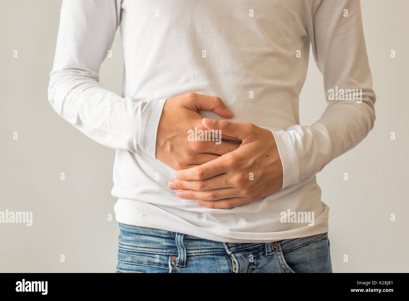 Young man suffering from stomach ache, diarrhea, constipation, acid reflux, indigestion, nausea Stock Photo