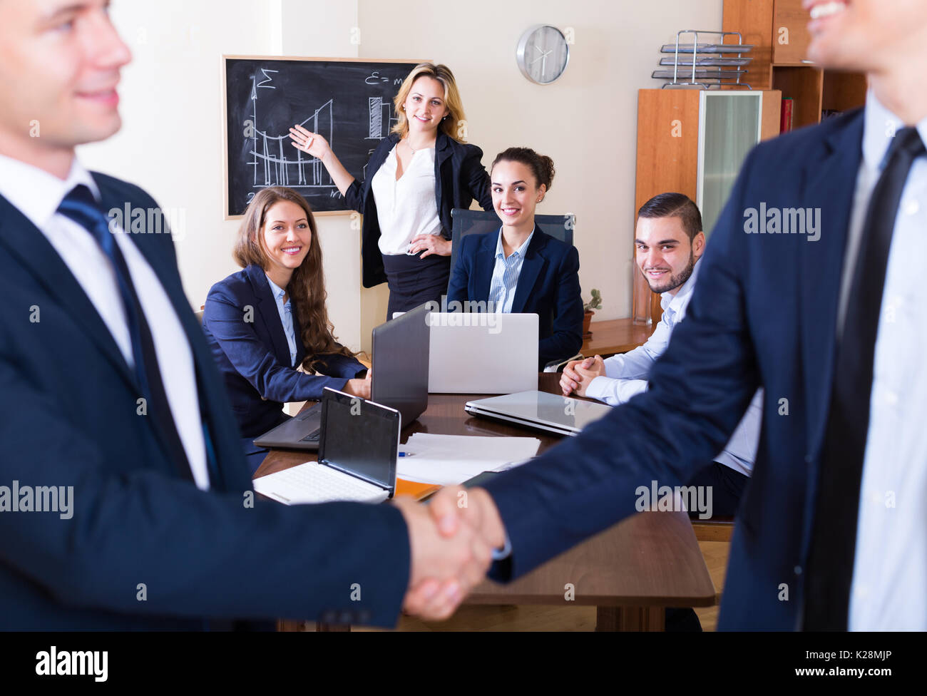 Successfully Dealt Two managers shaking hands and closing successful deal Stock Photo - Alamy