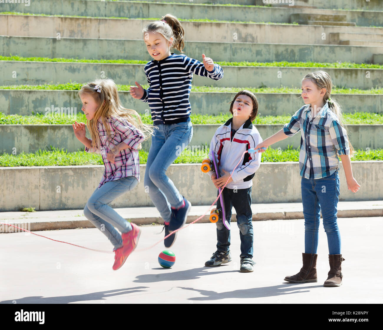 Young girl jumping while jump rope game with friends outdoor Stock ...