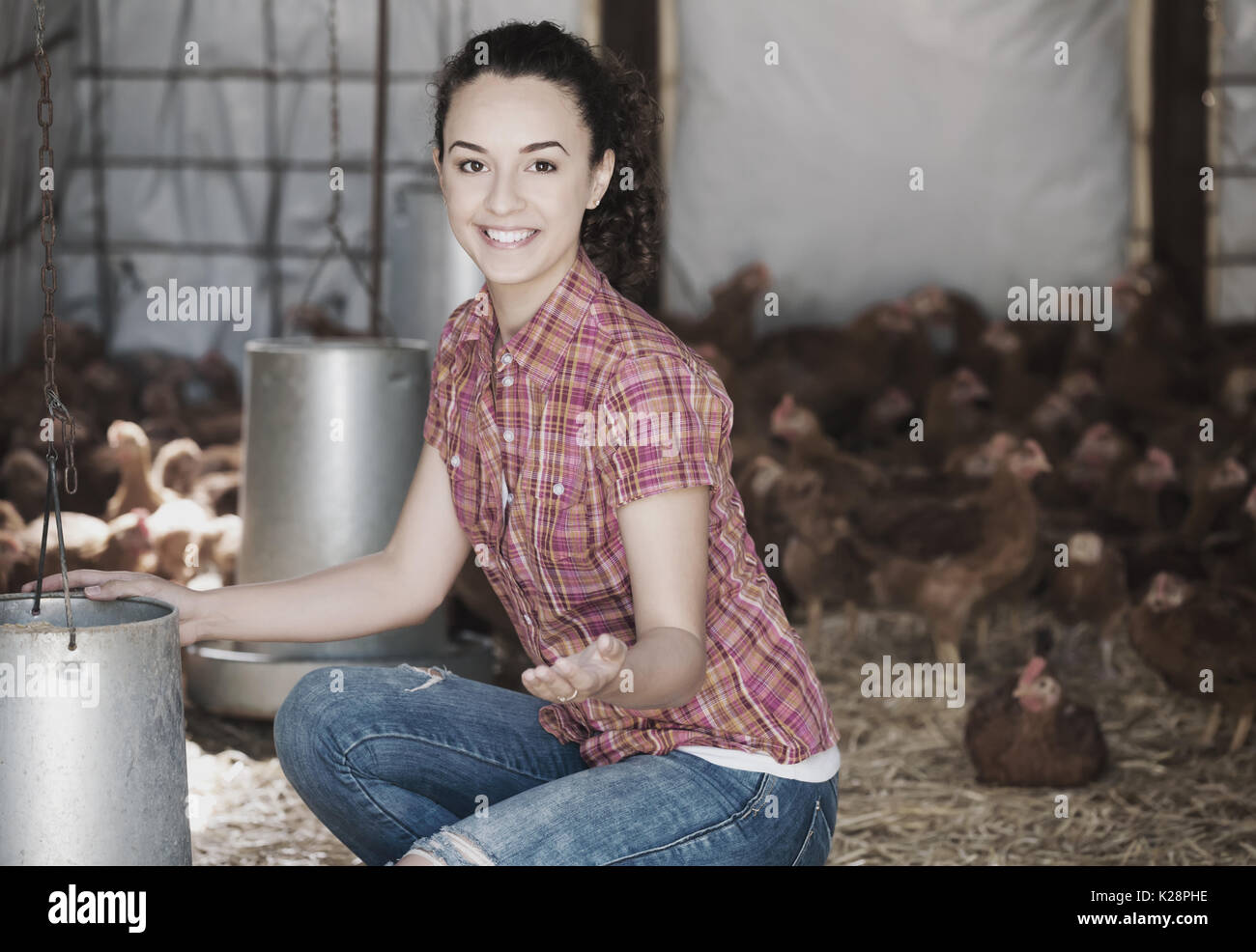 Happy woman farmer giving feeding stuff to chickens in farm house Stock ...
