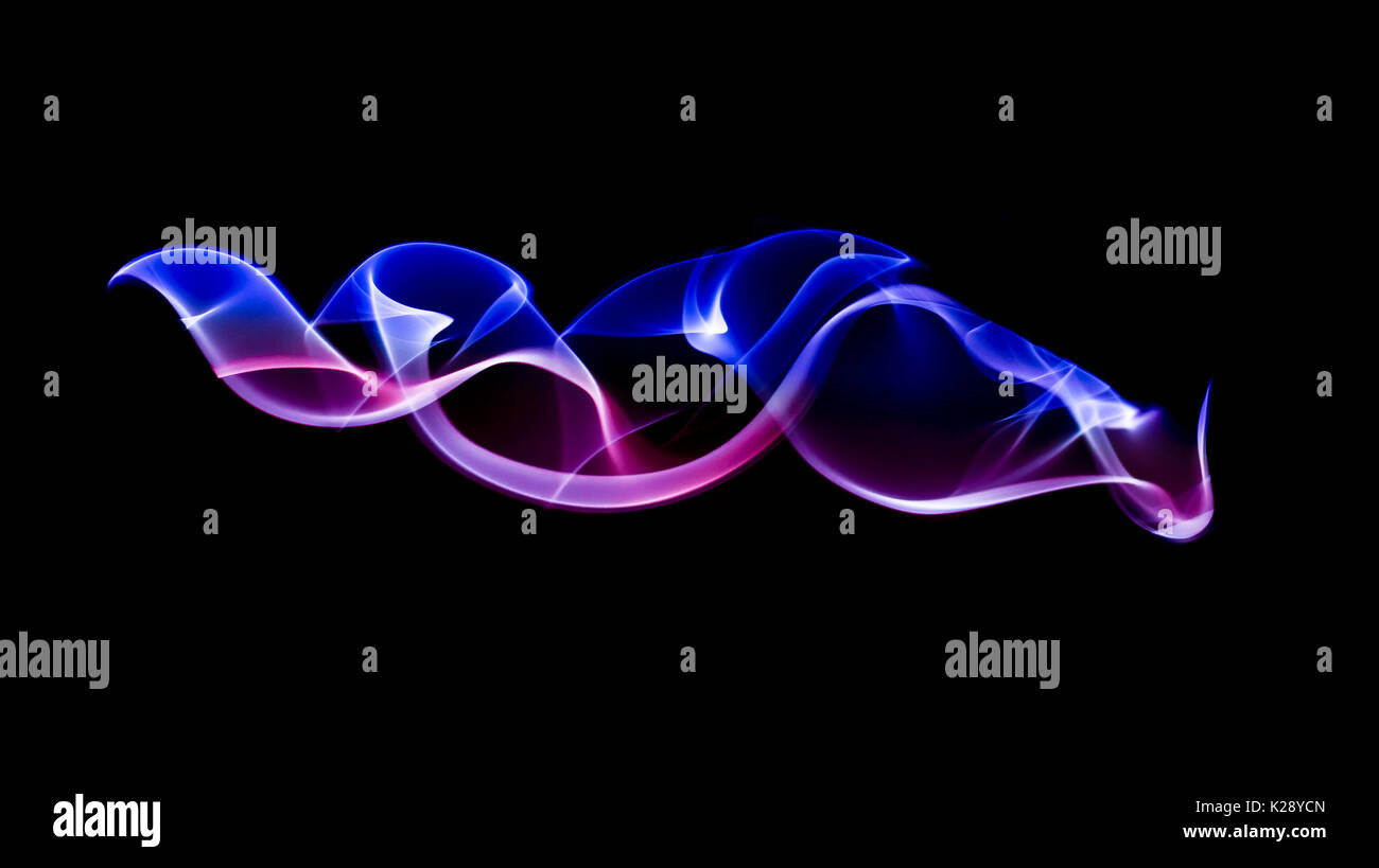 colored smoke spirals on a black background Stock Photo