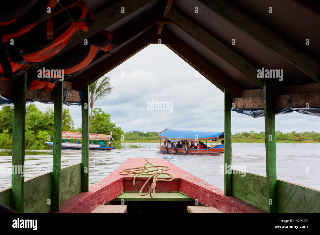 Riverboats in Nanay River, in Iquitos, Peru framed by boat structure. Nanay River connects the city to Amazon River. Stock Photo