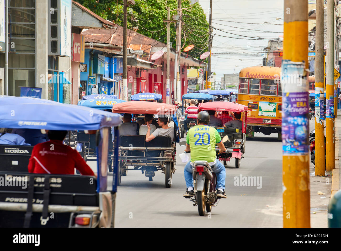 Very busy street in Iquitos, Peru. The popular mototaxis, a type of rickshaw, is the most popular form of the public transport in the city. Stock Photo