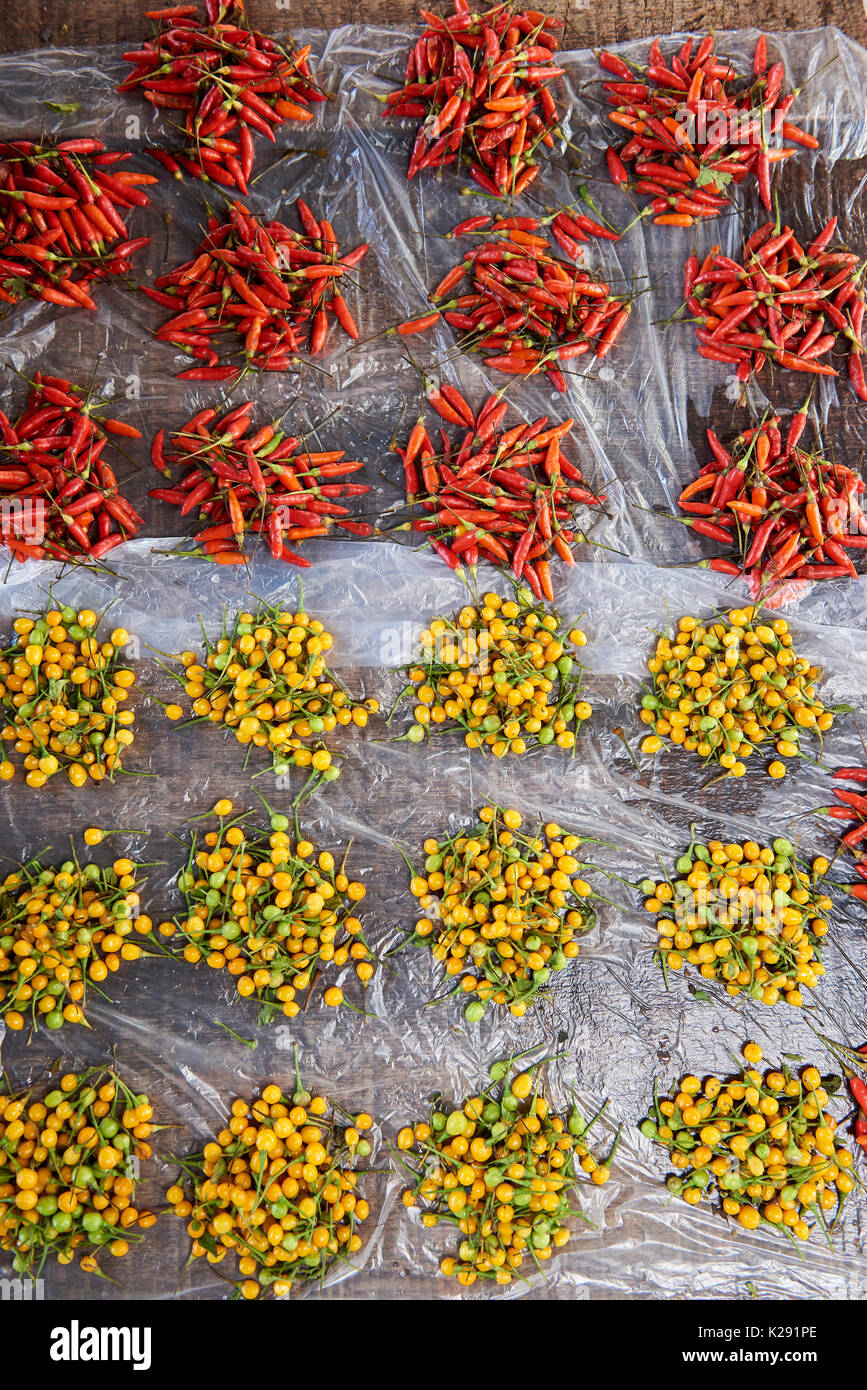 Portions of red chillies and yellow amazonian fruit being sold in Belem Market, Iquitos, Peru. Stock Photo