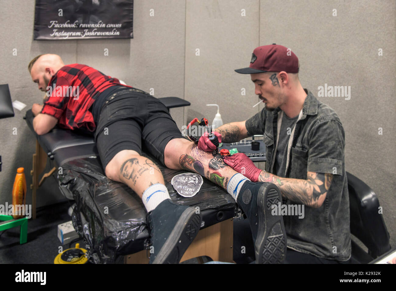 Tattoo - Josh Docksey tattooing the leg of a customer at the Cornwall Tattoo Convention. Stock Photo