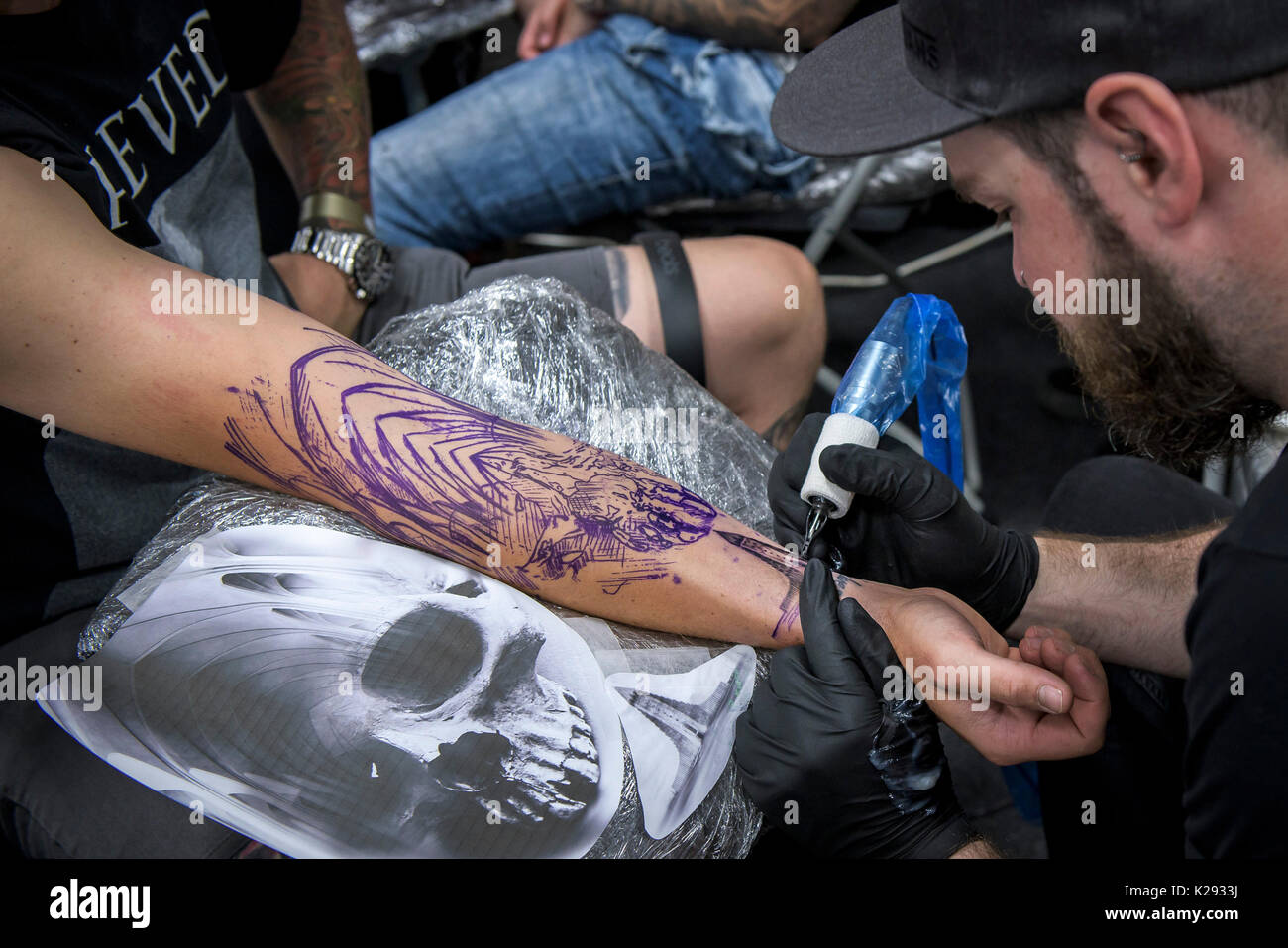 Cornwall Tattoo Convention - the forearm of a customer being tattooed at the Cornwall Tattoo Convention. Stock Photo