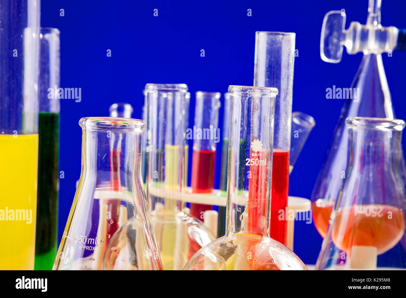 Colored liquid in chemistry set on a table over blue background Stock Photo