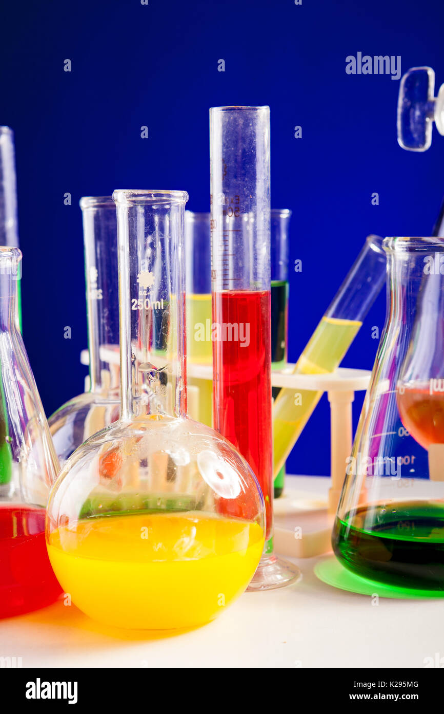 Colored liquid in chemistry set on a table over blue background Stock Photo