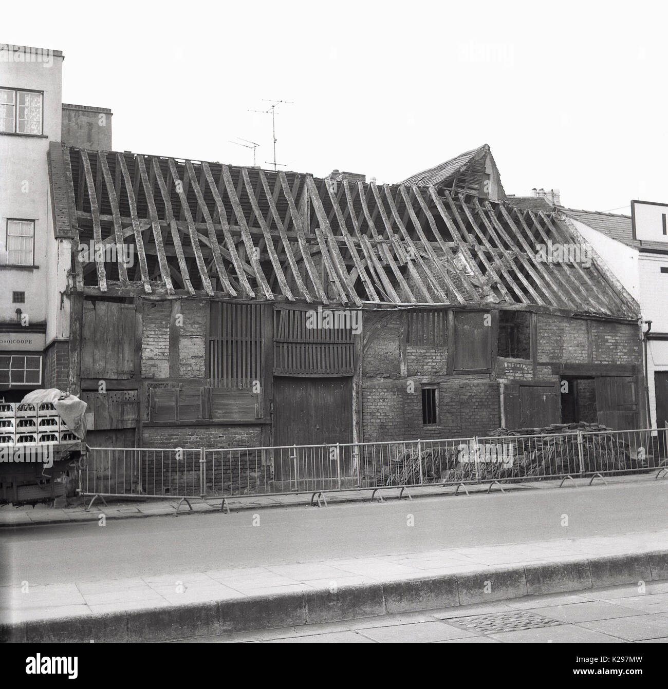 1960s, historical, picture shows exterior view of an ancient brick built storage barn in an english market town with an unsafe roof, its old wooden rafters are exposed to the elements with no tiles or coverings,  England, UK. Stock Photo