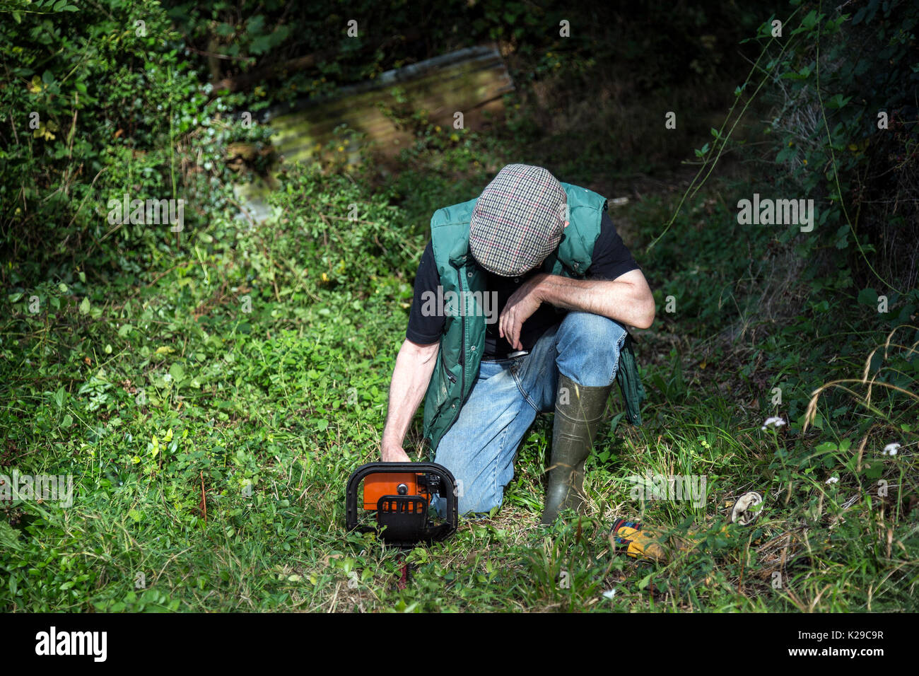 gardener with hedge trimmer in country lane Stock Photo