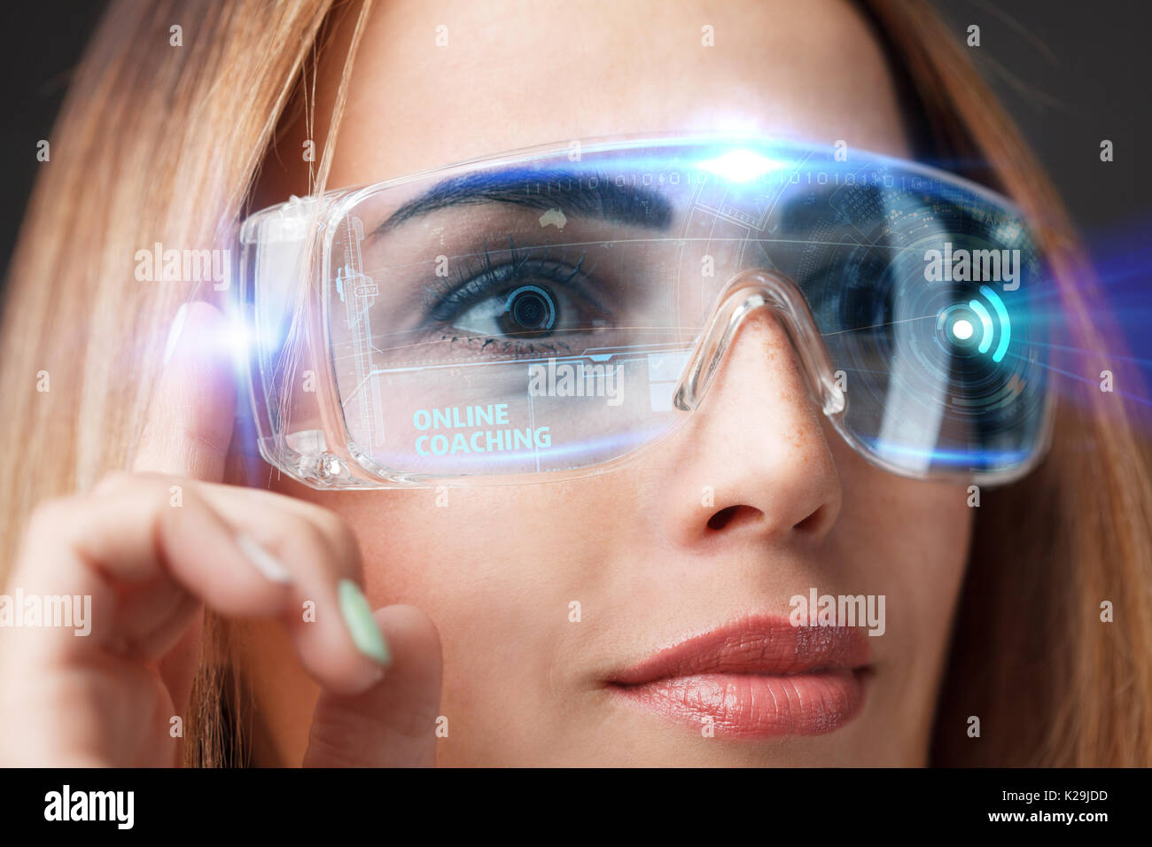 Young businesswoman working in virtual glasses, select the icon online coaching on the virtual display. Stock Photo