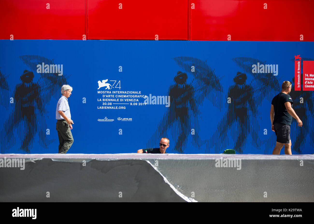 Venice, Italy. 29th Aug, 2017. Workers walk past the official poster of the 74th Venice International Film Festival, in Venice, Italy, on Aug. 29, 2017. The 74th Venice Film Festival will kick off in Lido of Venice on Aug. 30 and run until Sept. 9. Credit: Jin Yu/Xinhua/Alamy Live News Stock Photo