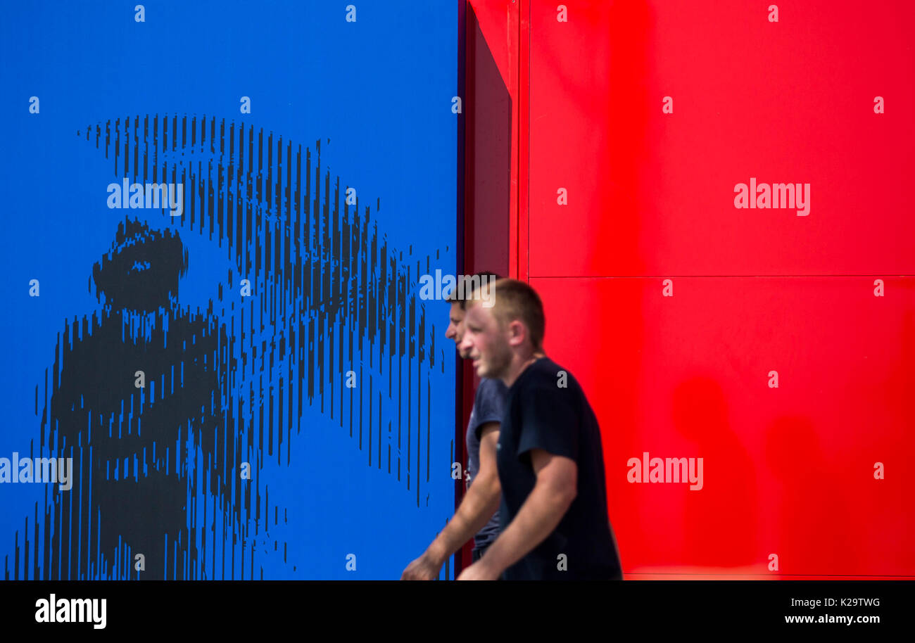 Venice, Italy. 29th Aug, 2017. Workers walk past the official poster of the 74th Venice International Film Festival, in Venice, Italy, on Aug. 29, 2017. The 74th Venice Film Festival will kick off in Lido of Venice on Aug. 30 and run until Sept. 9. Credit: Jin Yu/Xinhua/Alamy Live News Stock Photo