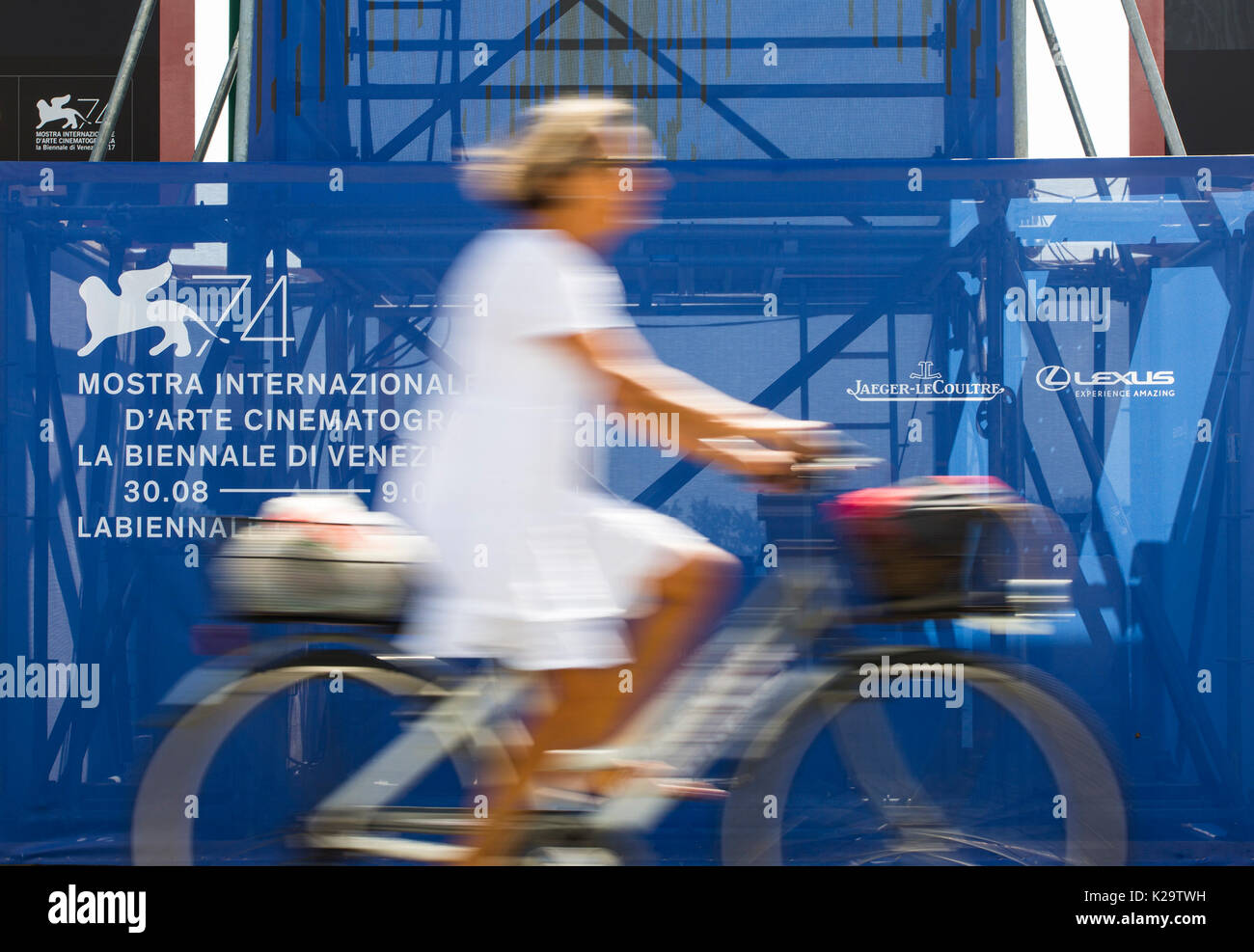 Venice, Italy. 29th Aug, 2017. A woman rides past the advertisement of the 74th Venice International Film Festival, in Venice, Italy, on Aug. 29, 2017. The 74th Venice Film Festival will kick off in Lido of Venice on Aug. 30 and run until Sept. 9. Credit: Jin Yu/Xinhua/Alamy Live News Stock Photo