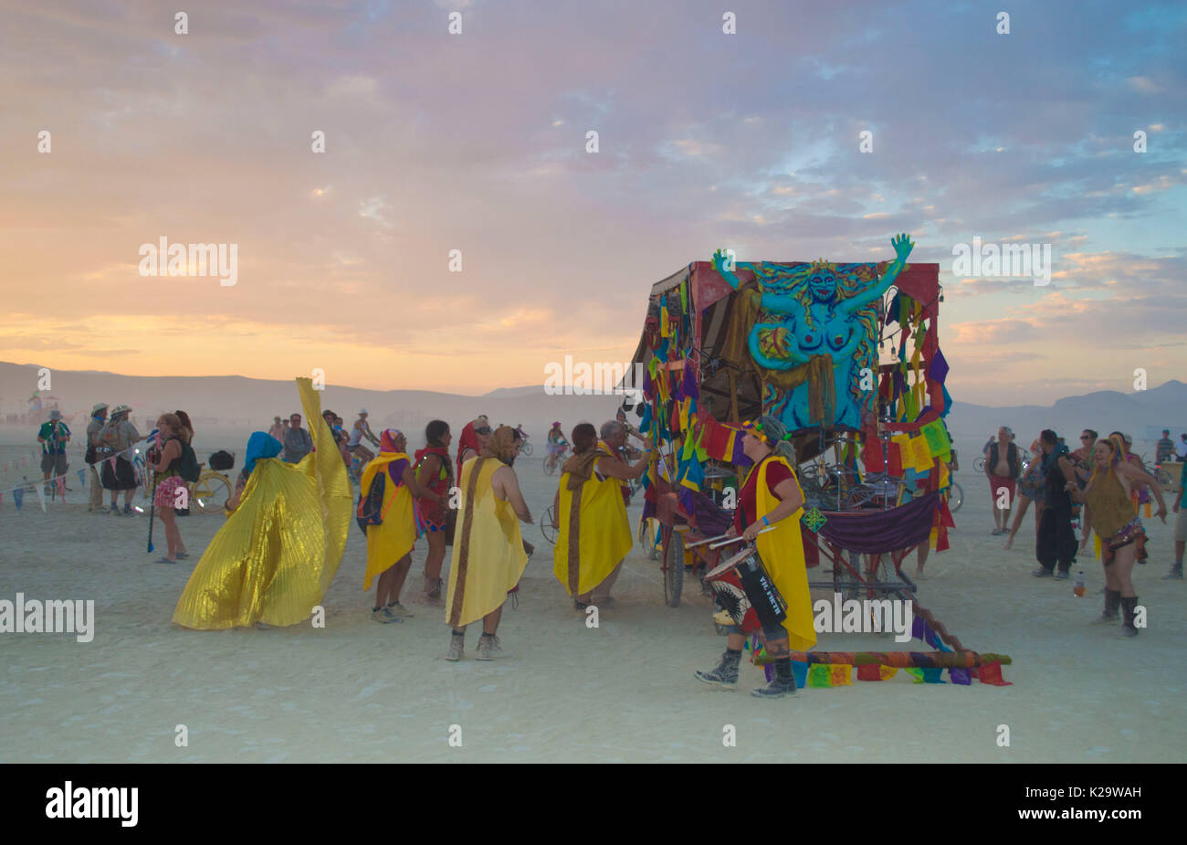 Burners lead a sunset procession on the playa as the annual desert