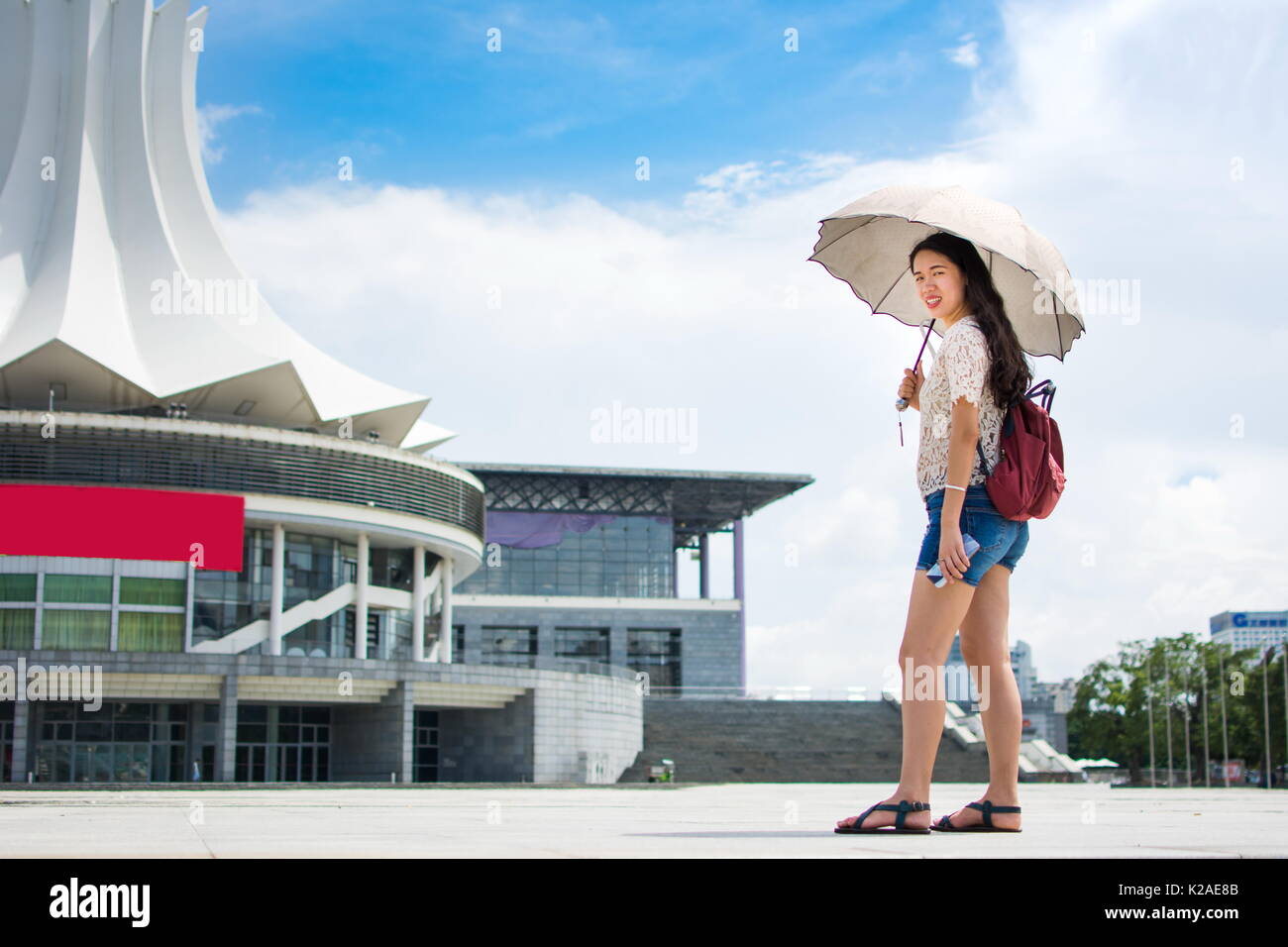 Asian tourist holding umbrella to protect from the strong sun Stock Photo