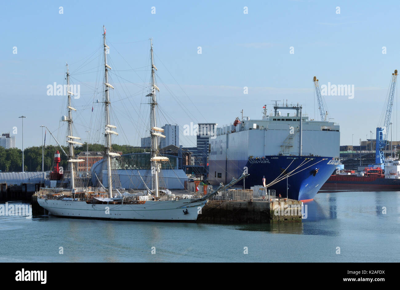 a modern car carrying ship transpoters and an old sailing ship or vessel together alongside at Southampton docks uk port contrast between new and old Stock Photo