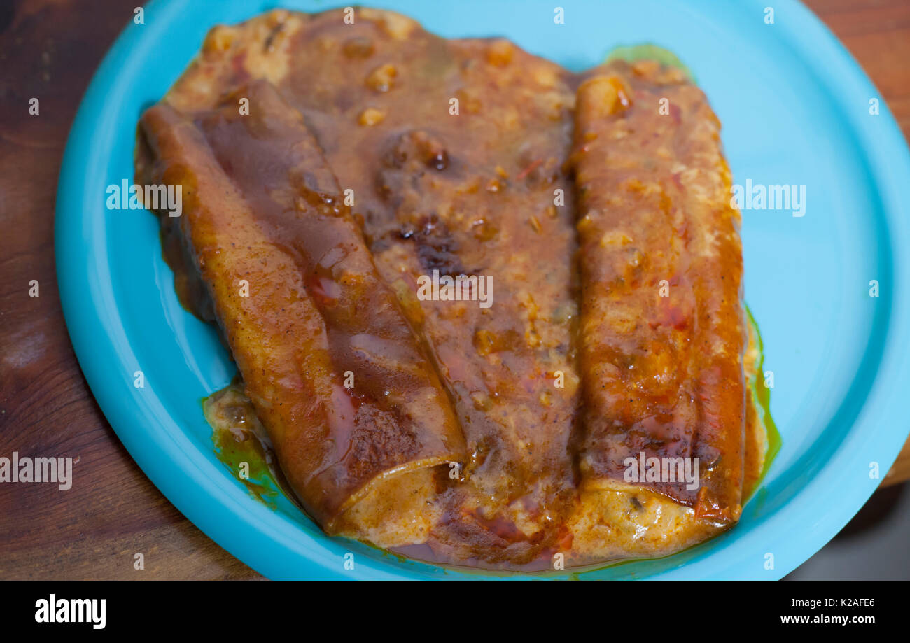 Close up of three cheese enchiladas on a pretty blue plate Stock Photo