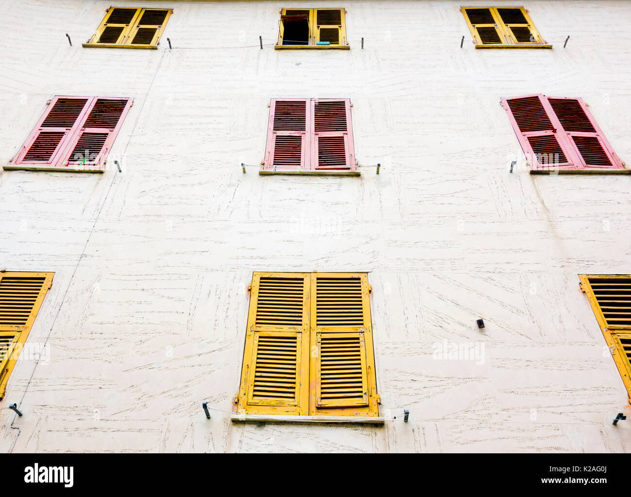 Marble facade building with yellow and pink shutters, Monterosso al Mare, Italy, 2017 Stock Photo