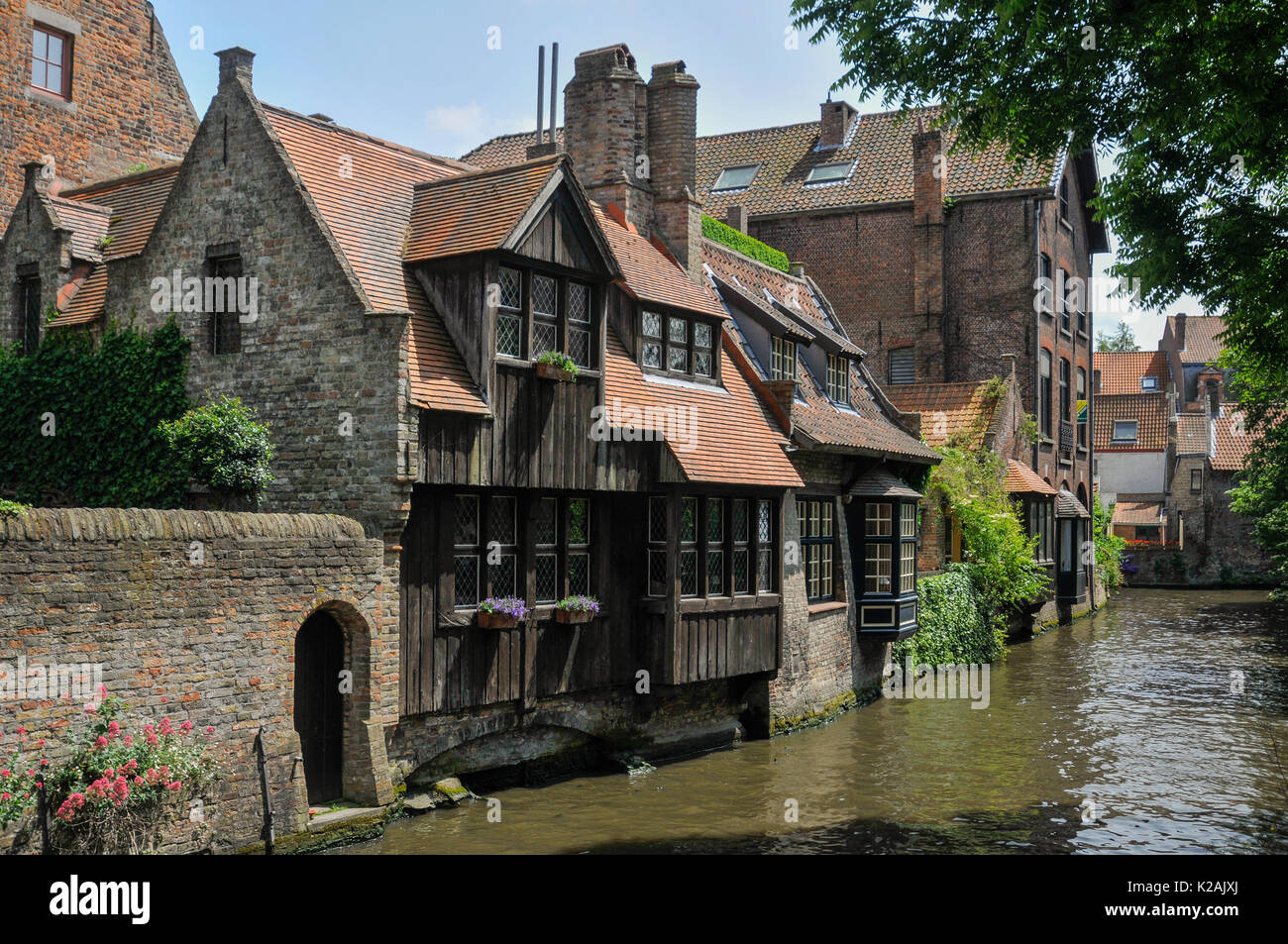A collection of stone and timber medieval buildings at the side of a peaceful canal in the centre of Brugge / Bruges in West Flanders, Belgium Stock Photo
