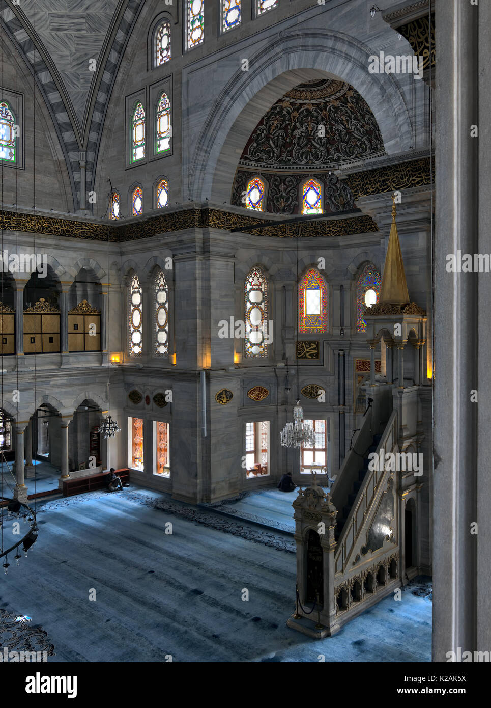 Interior shot of Nuruosmaniye Mosque, an Ottoman Baroque style mosque with minbar (platform), huge arches & colored stained glass windows located in S Stock Photo