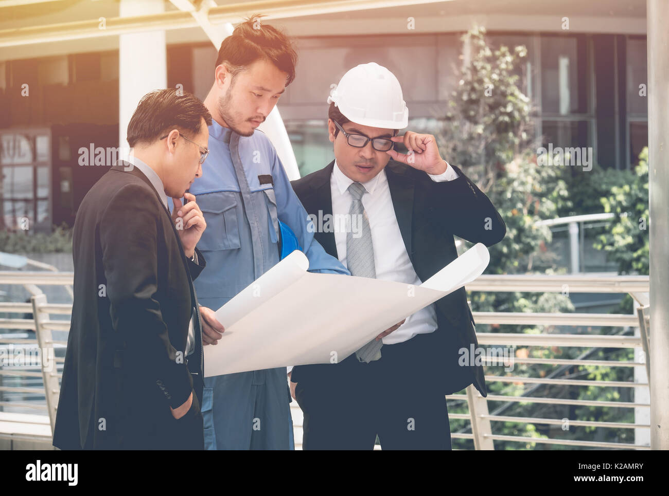 Team of architects and engineer at outdoor building and talking to planning work Stock Photo