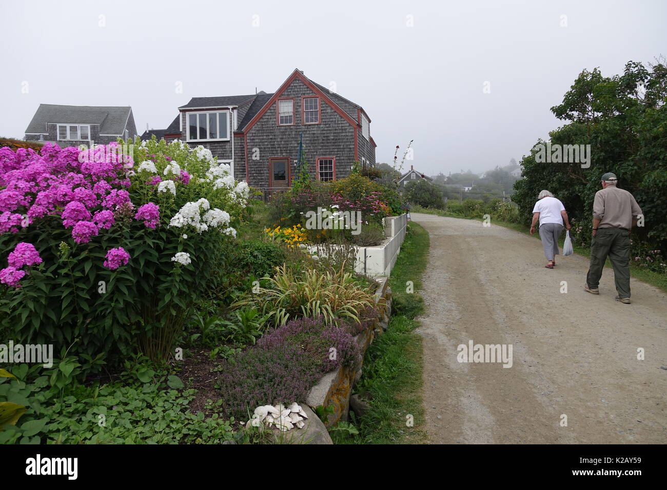 USA Maine ME Monhegan Island in Penobscot Bay in the Atalntic Ocean An older couple walking on Lobster Cove Road Stock Photo