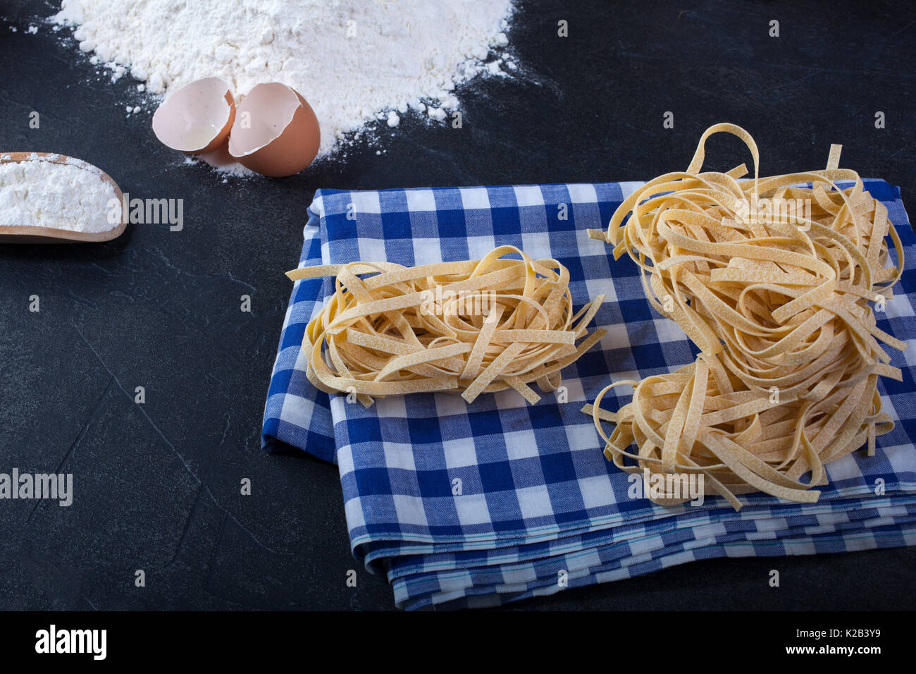 Italian homemade pasta called fettuccine on blue and white chequered