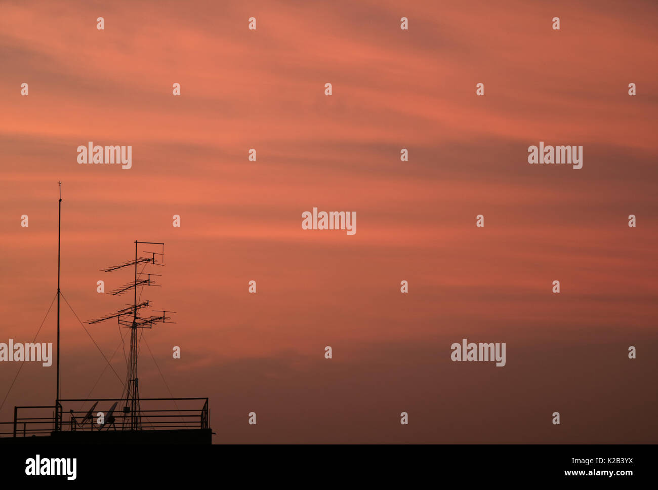 Silhouette of TV Antenna against Beautiful Pink Cloudy Sky at the Twilight of Bangkok,Thailand Stock Photo