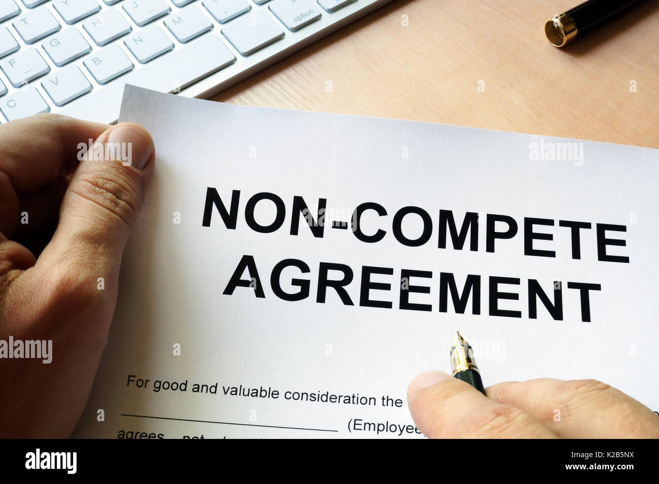 Man is signing Non compete agreement Stock Photo