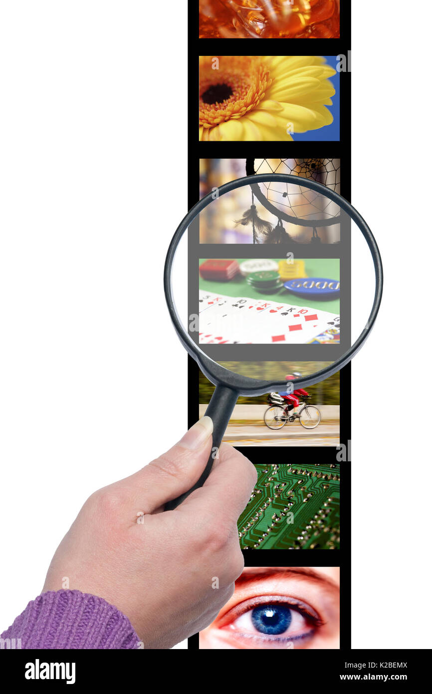 hand with magnifier looking at pictures, searching images concept Stock Photo
