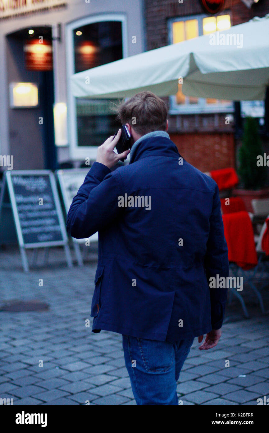 Young man with smartphone from behind Stock Photo