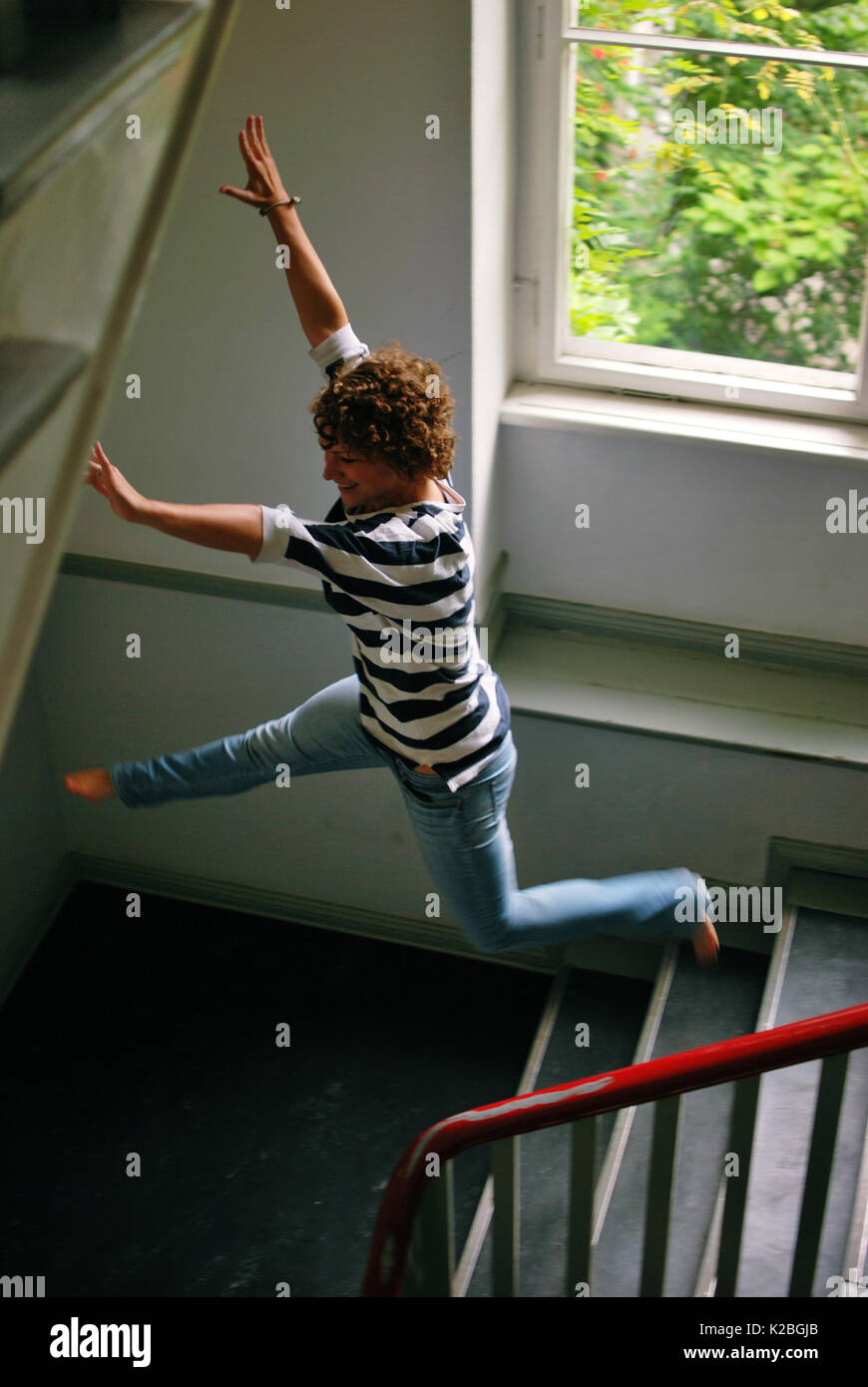 Girl doing a big jump on a staircase Stock Photo