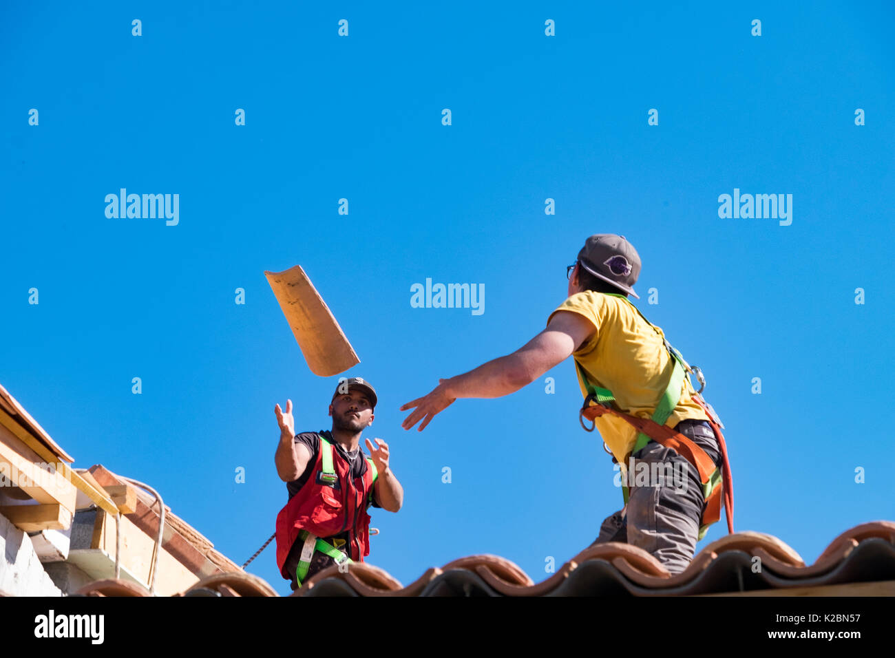 Roofers at work installing tiles on a new home in Provence, France Stock Photo