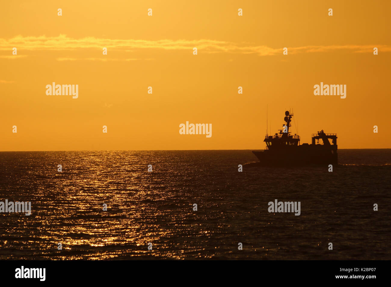 Sun setting over fishing vessel. North Sea, August 2015.  Property released. Stock Photo